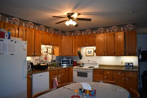 Shared kitchen with wooden cabinets and dining table.