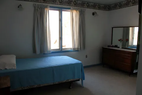 Bedroom with a bed, window and dressing table.