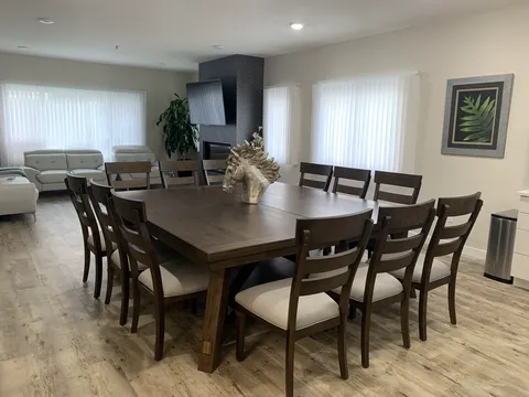 Shared dining and living area with a wooden table and sofas.