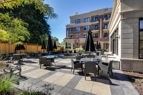 Residence beside a courtyard with tables, chairs and folded umbrellas