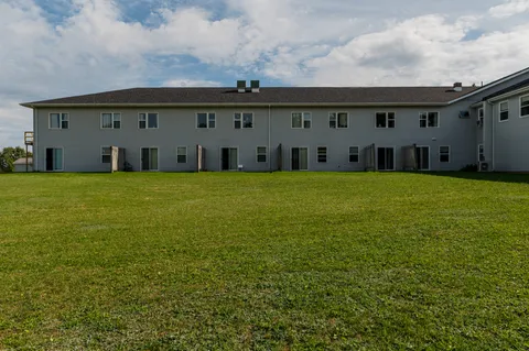 Two-storey rear wing of a building beside a broad green lawn