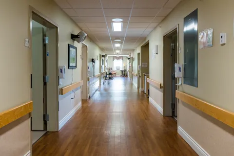Hallway with doors, handrails, wooden flooring and ceiling lights