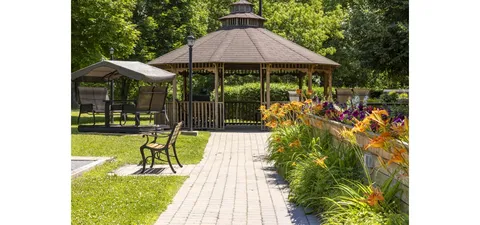 Gazebo with benches, paved paths and flowering plants