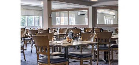 Dining room with set tables, wooden chairs and large windows
