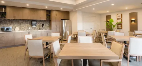 Dining tables and chairs beside a kitchen counter