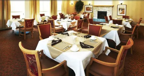 Dining room with set tables, red chairs and a stone fireplace