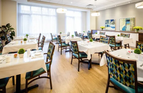 Dining room with set tables and chairs beside large windows