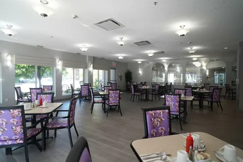 Dining room with tables, patterned chairs and large windows