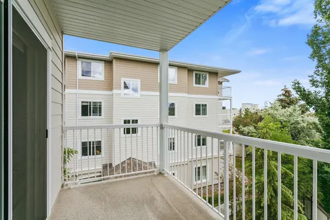 Covered balcony with white railings beside the residence