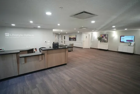 Room with a reception counter, wood flooring and a wall screen