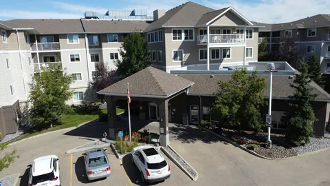 Multi-storey residence with a covered entrance and parked cars