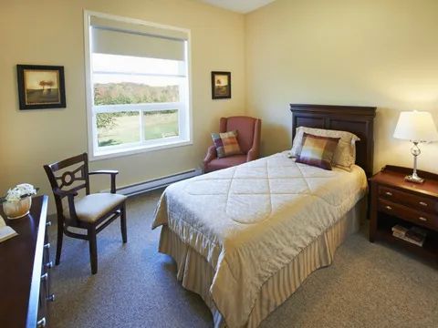 Bedroom with a single bed, an armchair and a window