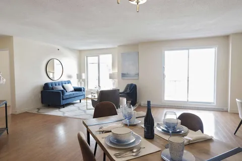 Suite living and dining area with a sofa and large windows.