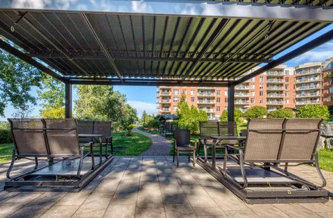 Patio with outdoor seating beneath a pergola.