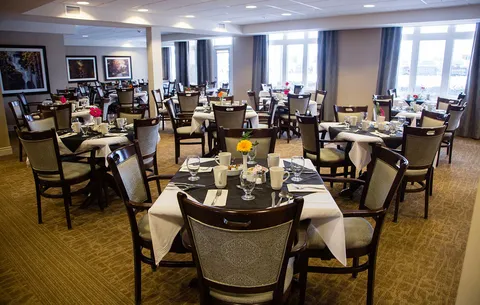 Dining room with set tables beside large windows.