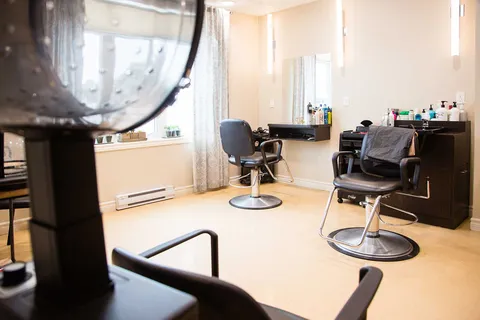 Hair salon with styling chairs and mirrors.