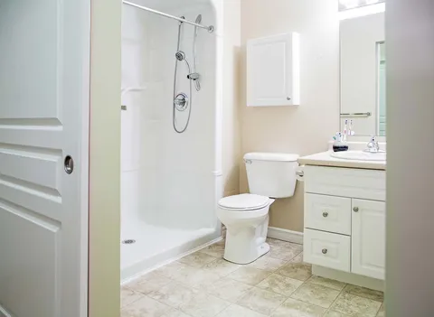 Accessible bathroom with shower, toilet and vanity.