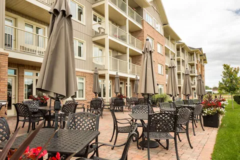 Patio with tables and chairs alongside the residence balconies.
