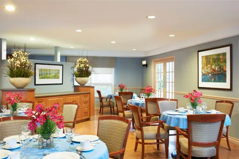 Dining room with round tables, chairs and blue tablecloths