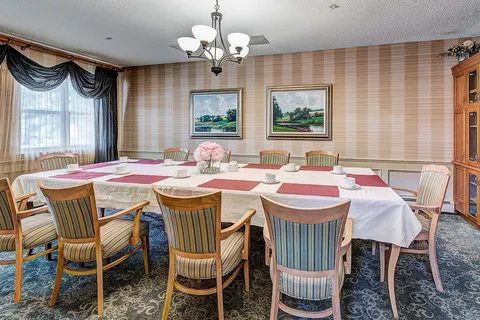 Private dining room with a long table and curtained windows.