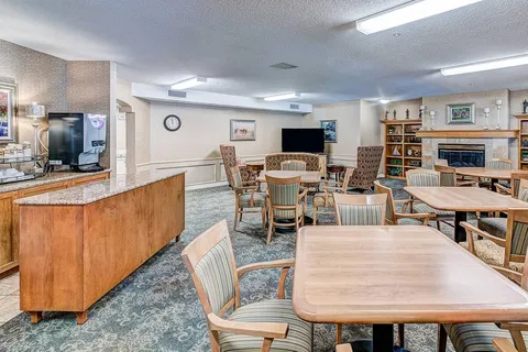Bistro tables beside a counter, television and bookcase.