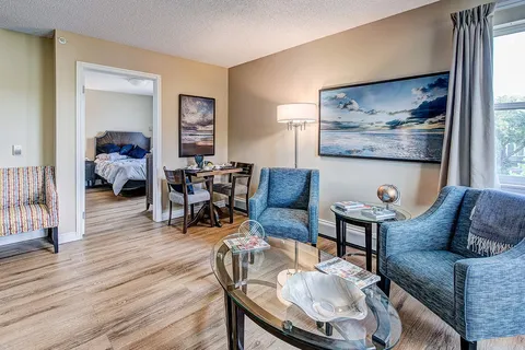 Suite sitting area with two armchairs and an adjoining bedroom.