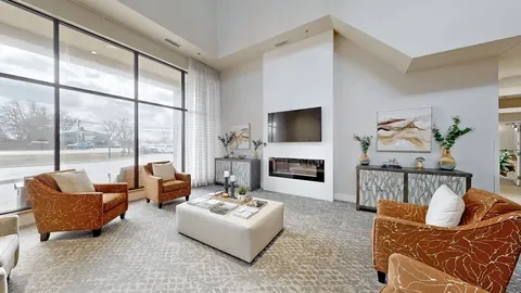 Sitting area with orange armchairs, a fireplace and a television