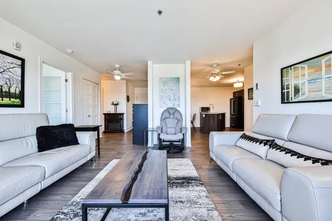Sitting area with white sofas, a wooden coffee table and a balcony door