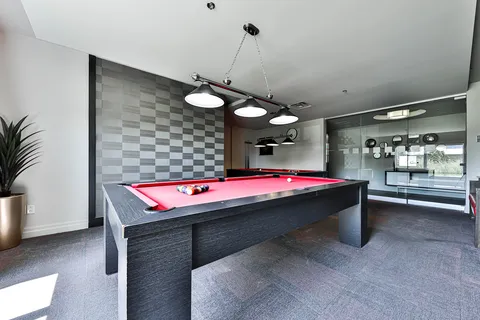 Room with a billiards table, armchairs and large windows