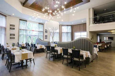 Two-storey dining room with set tables, large windows and a balcony