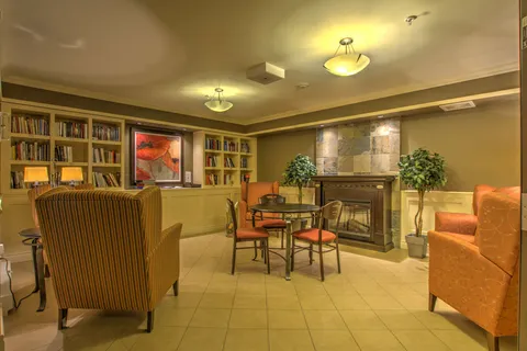 Library lounge with bookshelves and a fireplace.