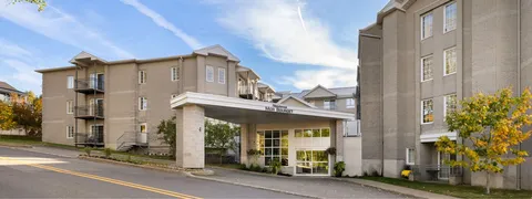 Residence buildings and covered entrance beside the street.
