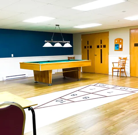 Games room with a pool table and a shuffleboard pattern on the floor.