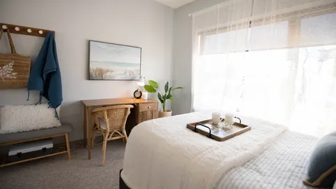 Bedroom with a bed, desk, chair and large window