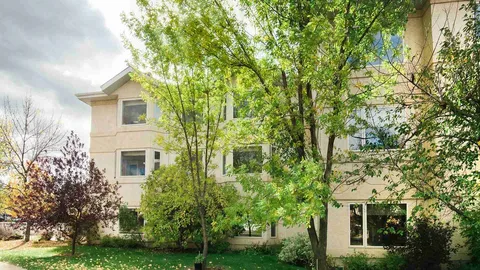 Residence exterior partly screened by leafy trees