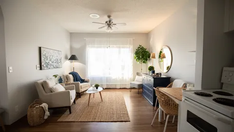 Sitting area with armchairs, a dresser, a table and a kitchenette