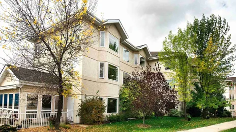 Three-storey residence with mature trees, a lawn and a covered patio