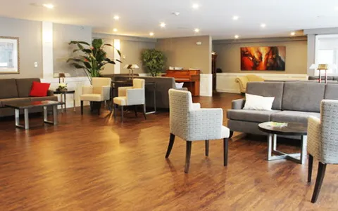 Sitting area with sofas, armchairs, small tables and a piano