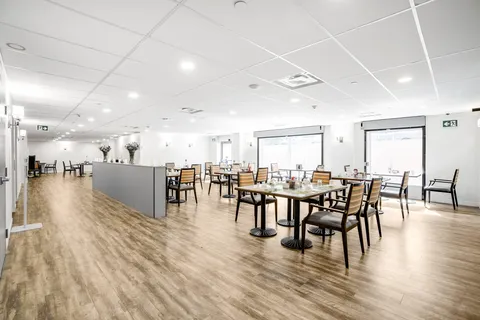 Dining room with tables, chairs and a service counter.