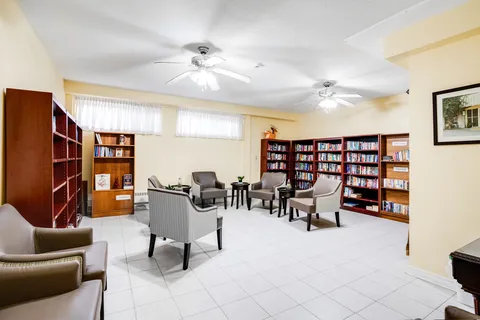 Library seating between bookshelves and windows.