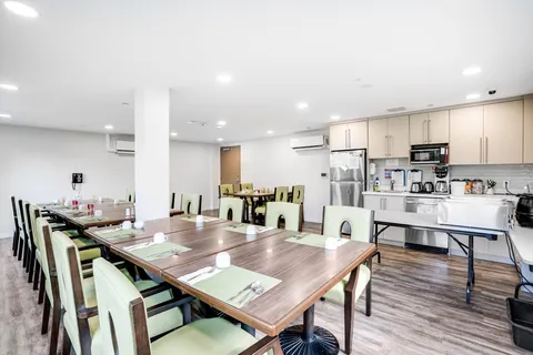 Dining table beside an open kitchenette.