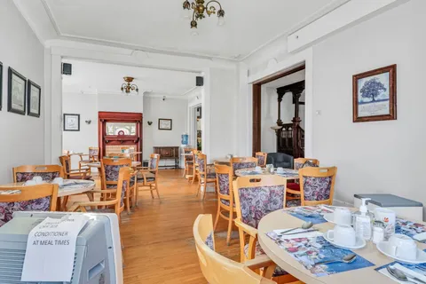Dining tables and wooden chairs beneath chandeliers