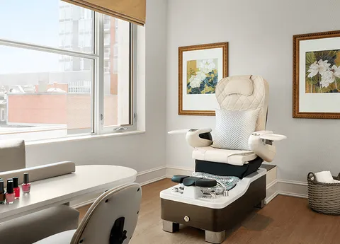 Spa room with a pedicure station beside a large window.