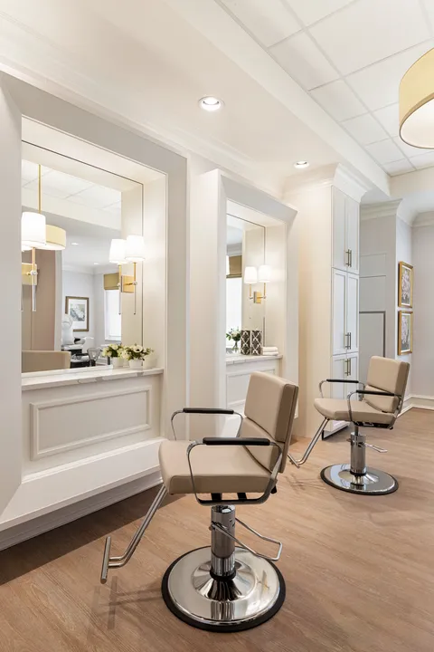 Salon styling chairs beside counters and mirrors.