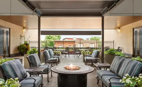 Covered rooftop terrace with seating around a fire table.