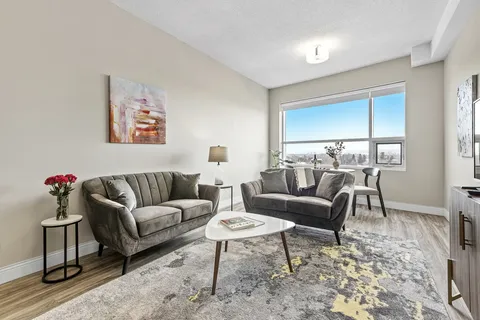 Sitting area with two grey sofas, a coffee table and window