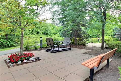Garden with a swing bench, flowers and lawn