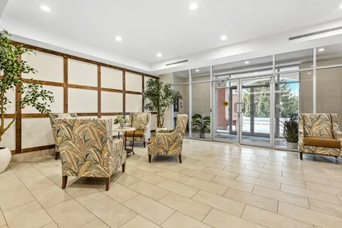 Lobby with armchairs, tables and glass entrance doors