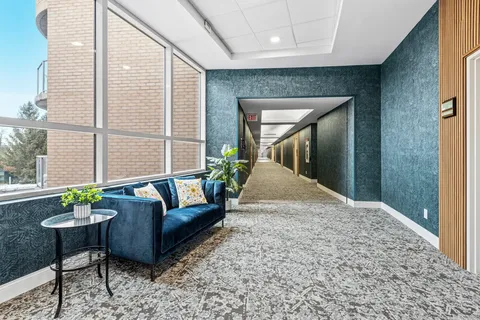 Hallway with blue walls, a sofa and wall lights