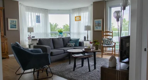 Suite living room with sofa, armchairs and large windows.
